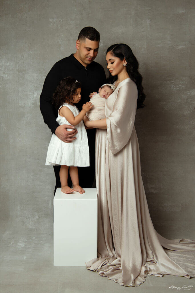 poses for family photography in a professional photo studio