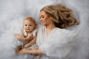 In studio family photography with mother and child with white props